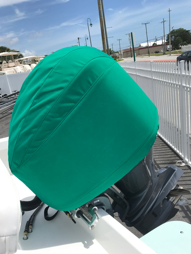 Green fitted cover protecting an outboard motor