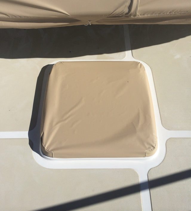 Tan fitted cover over a boat hatch