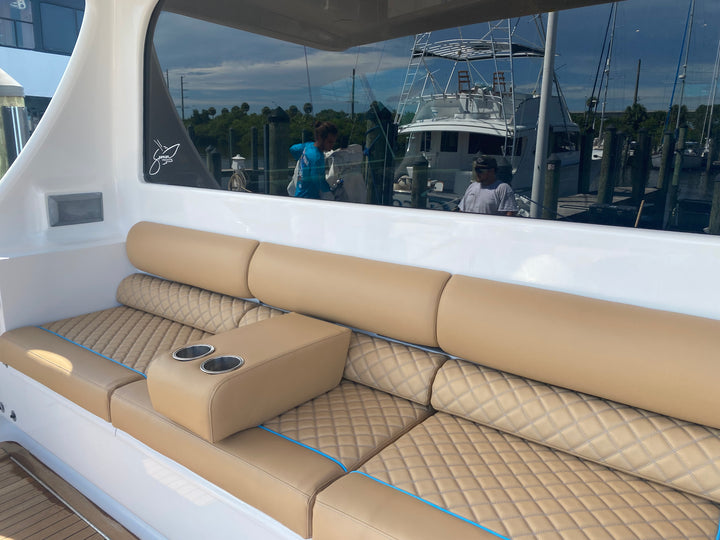 Tan quilted cockpit seating with blue piping and integrated cup holders
