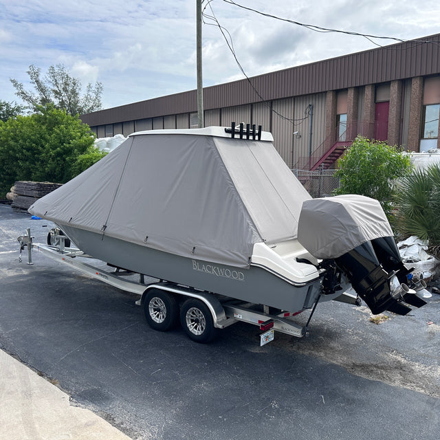 Gray fitted full boat cover with covered outboard motors on a center console boat
