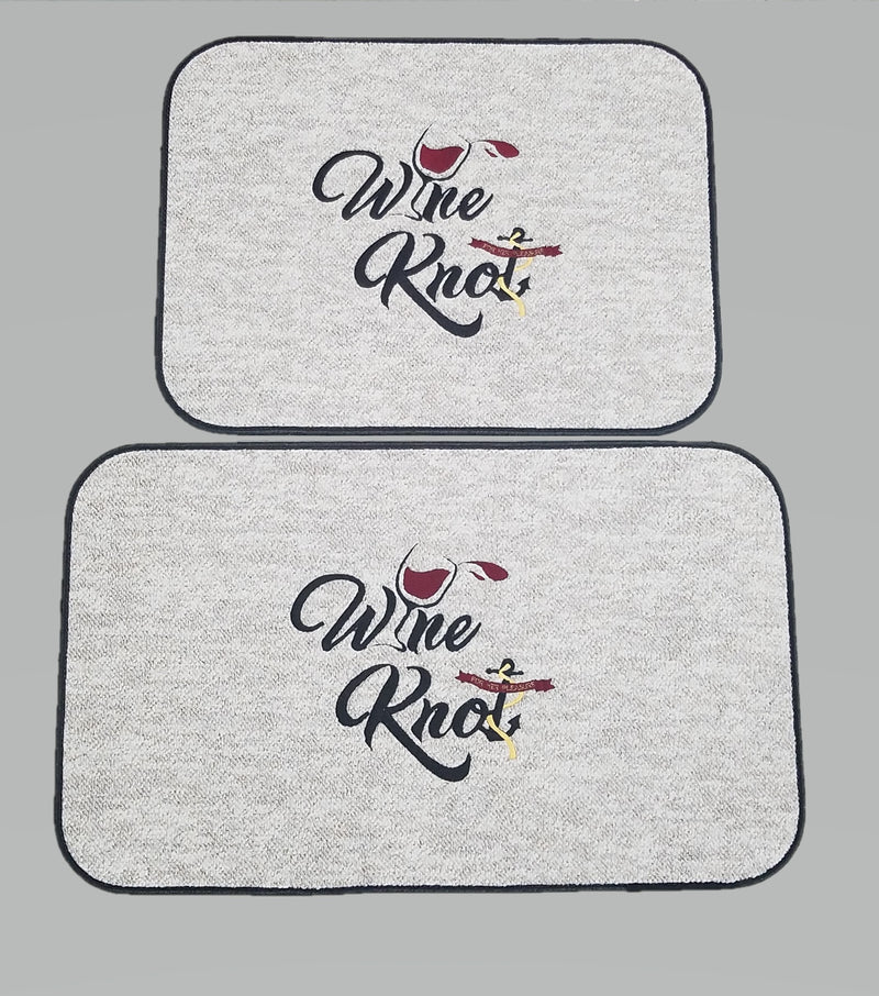 Two light-colored Wine Knot boarding mats with dark bound edges and wineglass-and-anchor artwork