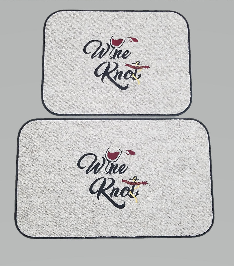 Two light-colored boarding mats embroidered with the name Wine Knot