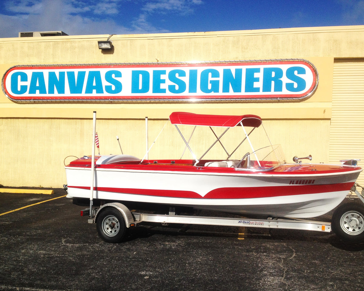 Red bimini top on a red-and-white boat outside the Canvas Designers workshop